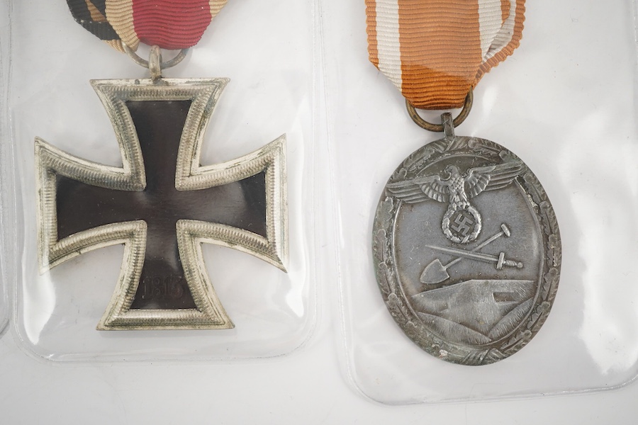 Nine German WWII medals; three Blood Order medals, a Second class Iron Cross, a War Merit medal in its original envelope, plus another unpacketed, a Second class War Merit cross, an Eastern Front Medal, and a West Wall M